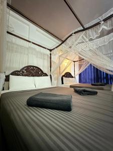 een groot bed met een net erop bij Poppies Mirissa in Mirissa