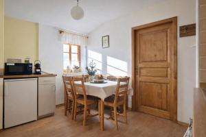 een keuken met een tafel en stoelen en een deur bij Krkonošská chaloupka in Cerny Dul