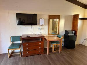 een kamer met een bureau en een tv aan de muur bij Royal inn in Quincy