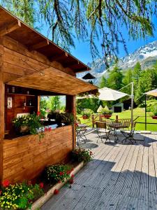 a wooden deck with a table and chairs at Grand Hôtel & Kurhaus in Arolla