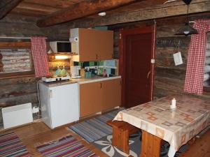 una cocina en una cabaña de madera con una mesa. en Ahkun Tupa, en Lemmenjoki