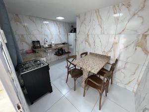 een keuken met een tafel, stoelen en een fornuis bij Flats Brisa Antunes in Maragogi +9 foto's