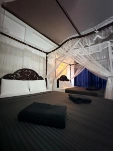een bed in een tent met een zwart kussen erop bij Poppies Mirissa in Mirissa