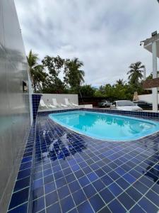 een zwembad met blauwe tegels op een gebouw bij Flats Brisa Antunes in Maragogi