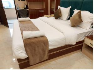 a bedroom with a large bed with white sheets and pillows at Hotel Gulmohar Tree in Jāmb