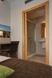 uma casa de banho com um chuveiro e uma porta de vidro em Hostal Agrobotiga 7 de Ribera em Móra d'Ebre