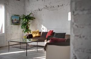 uma sala de estar com um sofá e uma mesa de vidro em Hostal Agrobotiga 7 de Ribera em Móra d'Ebre
