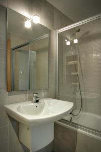 a bathroom with a sink and a shower and a mirror at Hostal Agrobotiga 7 de Ribera in Móra d'Ebre