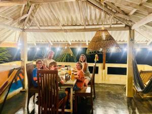 een gezin aan een tafel in een restaurant bij Amour Surf in Tangalle