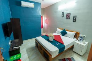een slaapkamer met een bed en een tv erin bij Aryas Residency- Near Isha Foundation Coimbatore & Karunya University in Alāndurai