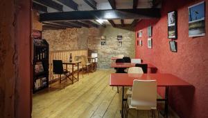 um restaurante com paredes vermelhas, mesas e cadeiras em Hostal Agrobotiga 7 de Ribera em Móra d'Ebre