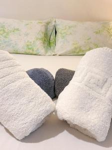 two white towels sitting on top of a bed at Μικρό διαμέρισμα 20μ από την κεντρική πλατεία in Kalamata