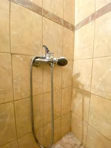 a shower in a tiled bathroom with a hose at Μικρό διαμέρισμα 20μ από την κεντρική πλατεία in Kalamata