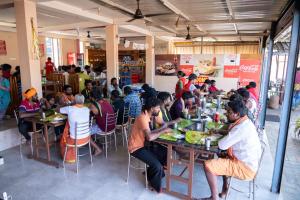 een groep mensen die aan tafel eten bij Aryas Residency- Near Isha Foundation Coimbatore & Karunya University in Alāndurai