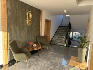 een woonkamer met 2 stoelen, een tafel en een trap bij Willa Górska Pasja in Szczyrk