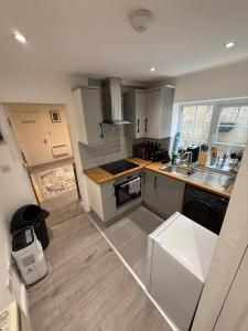 a small kitchen with white cabinets and a sink at Entire Apartment Bright & Spacious with Private Garden Near Victoria Park in London