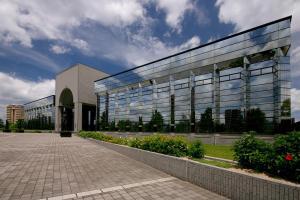 a large glass building with a courtyard in front of it at Seaside Hotel Twins Momochi in Fukuoka