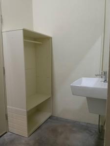 une salle de bain avec un lavabo et un meuble blanc dans l'établissement Tha Khao Beach House 1, à Ban Bang Chak