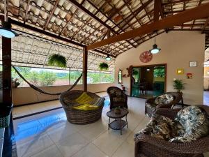 a living room with couches and a hammock in a room at Casa do Cerrado in Santana do Riacho