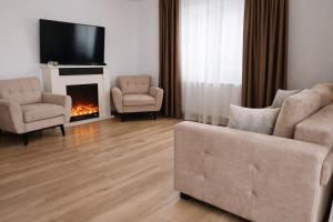 a living room with a couch and chairs and a fireplace at Liziera Cabin Malaia in Malaia
