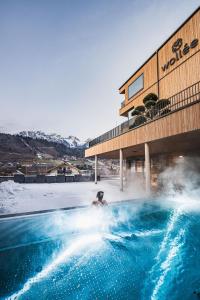 een persoon die in een warmwaterbron in een zwembad zit bij Alpine Boutique Hotel wollée in Schladming