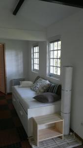 a bedroom with a bed and two windows at La Cabane des Beaux Chênes in Évrunes