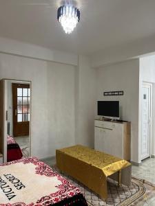 een woonkamer met een bed, een tafel en een televisie bij Magnifique Studio in Mostaganem