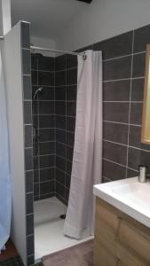 La salle de bains est pourvue d'une douche avec rideau de douche blanc. dans l'établissement La Cabane des Beaux Chênes, à Évrunes