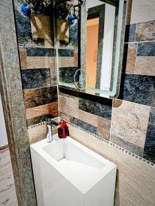 een badkamer met een witte wastafel en een spiegel bij Pyrs Giza Heaven in Caïro