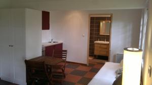 a room with a table and a sink and a bathroom at La Cabane des Beaux Chênes in Évrunes