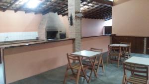 un ristorante con tavoli e sedie in una stanza di Refugio Massaguaçu a Caraguatatuba