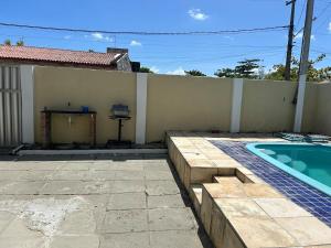 a backyard with a swimming pool next to a building at Casa ampla e completa a poucos passos da praia! in Itamaracá