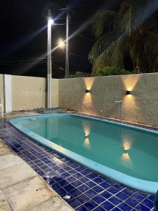 a blue swimming pool at night with lights at Casa ampla e completa a poucos passos da praia! in Itamaracá