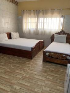deux lits dans une chambre avec parquet dans l'établissement MOTEL GLORY EL dilora, à Lomé