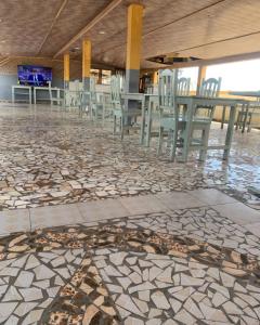 Cette chambre est dotée de carrelage ainsi que de chaises et de tables. dans l'établissement MOTEL GLORY EL dilora, à Lomé