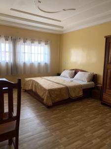 une chambre avec un grand lit dans une pièce dans l'établissement MOTEL GLORY EL dilora, à Lomé