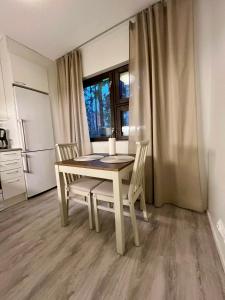 a table and chairs in a kitchen with a window at Modern studio apartment with free parking in Kuopio +4 photos