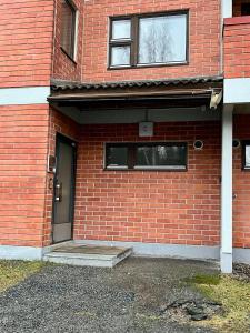 a brick building with a door and two windows at Modern studio apartment with free parking in Kuopio