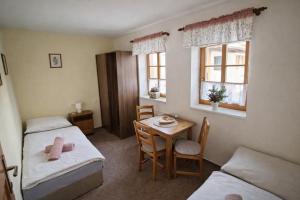 een kamer met twee bedden en een tafel en een tafel met stoelen bij Krkonošská chaloupka in Cerny Dul