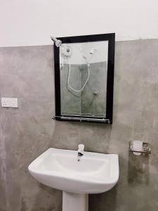 een witte wastafel in een badkamer met een spiegel bij Madu - Guesthouse & Local Restaurant in Weligama +17 foto's