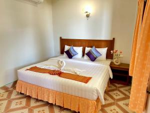 een slaapkamer met een groot bed met witte lakens en kussens bij Sunsea Resort in Baan Khai
