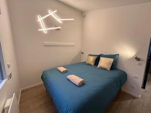 a bedroom with a blue bed with two pillows on it at Solar Dream - close to Disney in Lagny