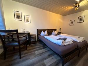 a bedroom with two beds and a desk and a chair at Hotel Mühlental in Wernigerode