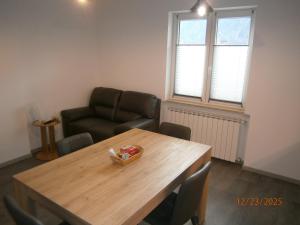 un soggiorno con un tavolo di legno e un divano di Residence ai fiori - Simone Apartment ad Arta Terme