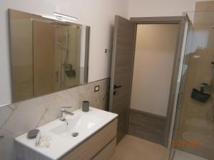 un bagno con lavandino e doccia di Residence ai fiori - Simone Apartment ad Arta Terme