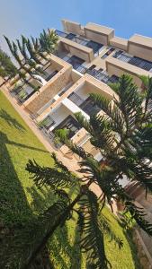 un edificio con delle palme di fronte di Jacob's Courts Apartment 6 a Kampala