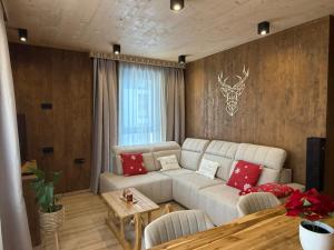 een woonkamer met een witte bank en een tafel bij Apartmán Forest, Tatranská Štrba in Tatranska Strba