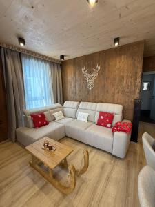 een woonkamer met een witte bank en rode kussens bij Apartmán Forest, Tatranská Štrba in Tatranska Strba