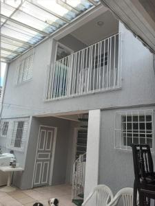 a house with a balcony and a dog laying on a patio at Hostelval Cantinho praia do sossego in Praia Grande