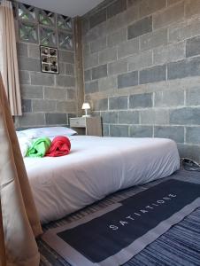 een bed in een kamer naast een bakstenen muur bij บ้านนอร์ดบล็อกเวนิสบ้านเวร in Ban Khun Nam Nan